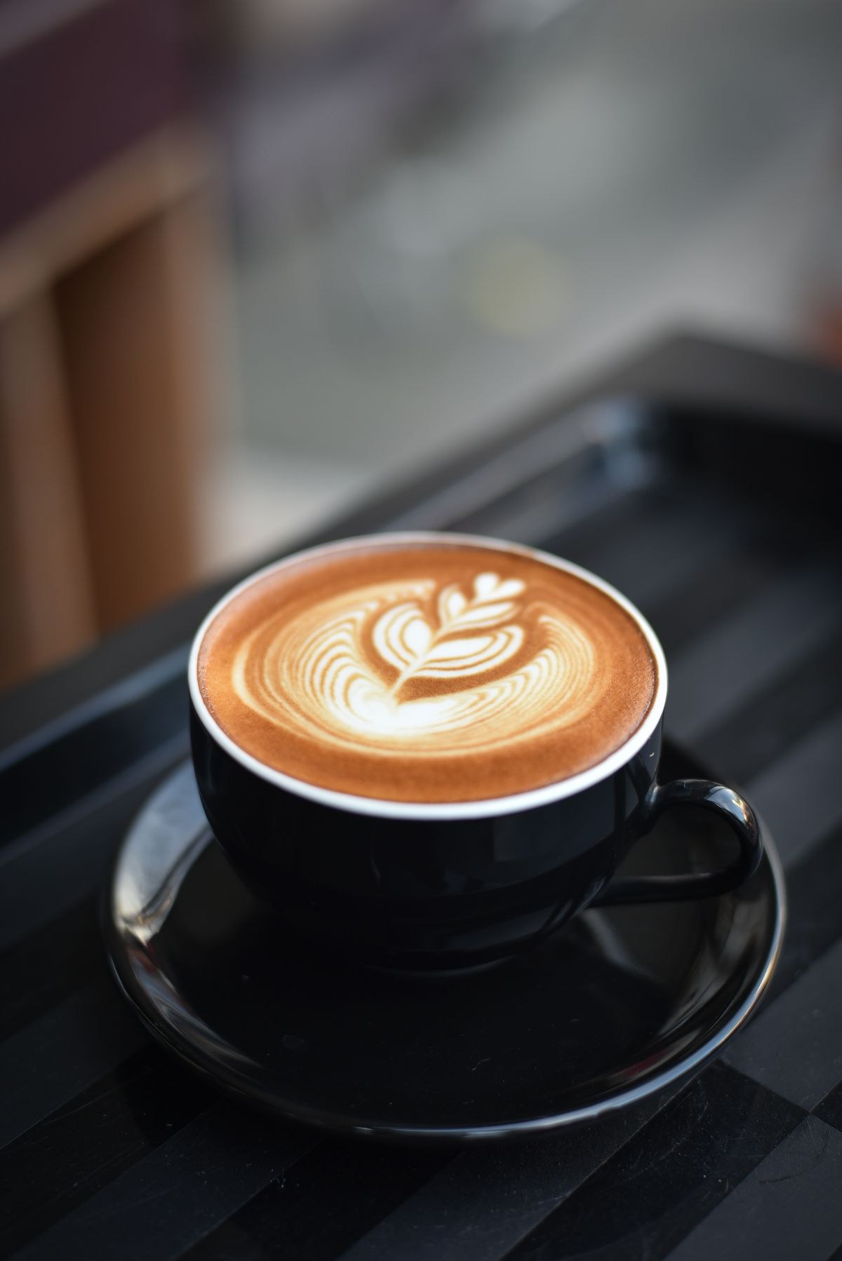Close detail of kopi o in a glass, dark surface and thin steam